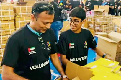  ?? Supplied Photos ?? Rian Pinto and his father pack school kits for students from the low-income families in the UAE. —