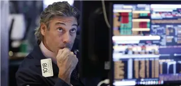  ??  ?? MARKETS ON EDGE: Trader John Romolo works at the New York Stock Exchange Wednesday as stocks fell. Jitters are being attributed to the trade war with China.