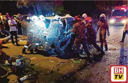  ?? (Foto Ihsan Bomba) ?? Anggota Bomba dan Penyelamat mengeluark­an mayat mangsa yang tersepit dalam kenderaan.