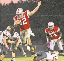  ??  ?? Tyler Blalock takes a leap over a Pepperell defender during the second quarter on Sept. 9.