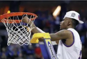  ?? CHARLIE NEIBERGALL — THE ASSOCIATED PRESS ?? Kansas’ Lagerald Vick cuts down the net after defeating Duke 85-81 in overtime of a regional final game in the NCAA men’s college basketball tournament Sunday in Omaha, Neb.