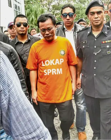  ??  ?? Day in court: MACC officers escorting Mohd Shafie to the magistrate court in Kota Kinabalu.