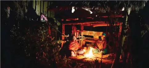  ??  ?? Surkhet, Nepal: In this photograph, Nepalese women Pabitra Giri, left, and Yum Kumari Giri, right, sit by a fire as they live in a Chhaupadi hut in Surkhet District, some 520km west of Kathmandu. —AFP