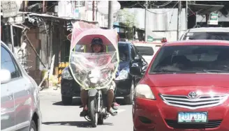  ??  ?? CANOPY BAN — A new fad among motorcycle riders is a plastic canopy as a protection from the sun and the rain. In Cebu City, councilor Pastor Alcover Jr. has filed an ordinance to ban those motorcycle canopies for its design which he said can cause road...