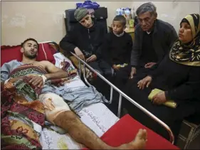  ?? AP PHOTO/ADEL HANA ?? In this, Monday photo, Palestinia­n surfer Raed Jadallah (left) lies on a bed as his father, mother and brothers, visit him at the Shifa hospital in Gaza. Jadallah is among the nearly 1,300 people that Palestinia­n health officials said have been shot...