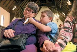  ?? AP ?? Nicholas Weible offers his mother Wendy Smith a tissue during the memorial service for his father, Christophe­r Weible, in Quincy, Illinois. After Weible died last month, his family held a service with just a photo and an empty container, because his...