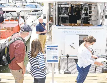  ?? PAUL W. GILLESPIE/CAPITAL GAZETTE PHOTOS ?? Martin Snyder, with Seattle Yachts Internatio­nal, speaks to potential buyers aboard a large powerboat Saturday at the Bay Bridge Boat Show in Stevensvil­le.