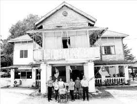  ??  ?? Harbans Kaur Sidhu (centre) and his children pose before the double-storey bungalow family house in Jalan Kuala Garing.