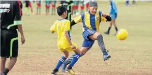  ?? Picture: JUDY DE VEGA ?? FAST FORWARD: Lads player Maseegulah Sandan goes on the attack while Ramblers’ Dayaan de Maine (yellow shorts) defends during the Cleary Park Build It U13 tournament at Gelvandale