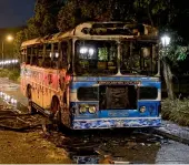  ?? ?? tries to help anti-government protestors who are being attacked by government supporters. (Right) Charred remains of a bus is pictured near Sri Lanka’s outgoing Prime Minister Mahinda Rajapaksa’s official residence in Colombo— ap, afp