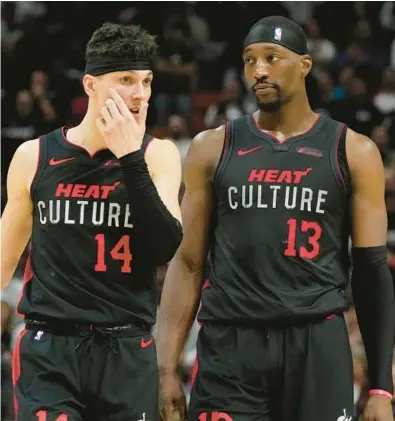  ?? MARTA LAVANDIER/AP ?? Heat guard Tyler Herro, left, and center Bam Adebayo talk on the court during the second half Jan. 19 in Miami. The Hawks defeated the Heat 109-108.