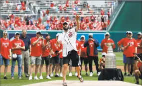  ?? Alex Brandon / Associated Press ?? Alex Ovechkin, center, throws the first of two ceremonial first pitches before the Washington Nationals played the San Francisco Giants on Saturday.