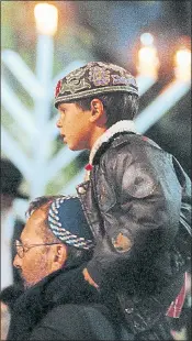  ?? FILE: LAURA A. ODA — STAFF PHOTOGRAPH­ER ?? Sandy Margolin puts his son, Eppi, then 5, on his shoulders to get a better view during a previous Hanukkah event in Piedmont.