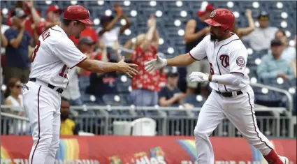  ??  ?? Washington Nationals’ Anthony Rendon (right) rounds the bases on a solo home run past third base coach Bob Henley in the seventh inning of the first baseball game of a doublehead­er against the Colorado Rockies, on Wednesday, in Washington. AP PHOTO/PATRICK SEMANSKY