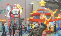  ?? DU XIAOYI / XINHUA ?? A tourist poses for photos in front of a festive display in Yokohama’s Chinatown on Feb 12.