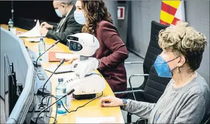  ?? LLIBERT TEIXIDÓ ?? El robot, entre Margarida Valls en primer plano y la teniente de alcalde Laura Pérez, ayer el Ayuntamien­to