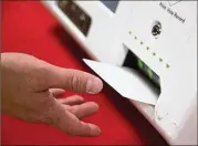  ?? STEVE SCHAEFER / SPECIAL TO THE AJC ?? Jeb Cameron of Election Systems and Software pulls a paper ballot from a voting machine during a demonstrat­ion in 2017 at the Rockdale County Board of Elections office in Conyers.