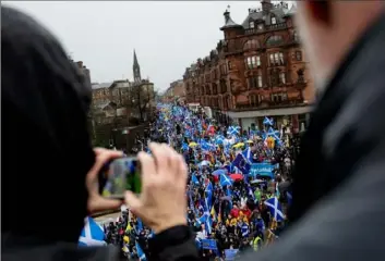  ?? Emily Macinnes/Bloomberg ?? Demonstrat­ors march with various flags across a road junction during an All Under One Banner march for Scottish independen­ce in Glasgow, Scotland, on Jan. 11.