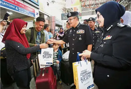  ??  ?? Festive gifts: Mazlan (second from right) and Crime Prevention and Community Safety Department acting head Asst Comm Latt Mazura Mansor giving out goodie bags after the launch of ‘Ops Selamat Hari Raya’ at KL Sentral.