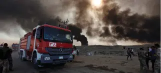  ??  ?? Terra bruciata. I soccorsi e la colonna di fumo vicino agli impianti petrolifer­i dati alle fiamme dai jihadisti dell’Isis in fuga a Qayyarah vicino a Mosul.