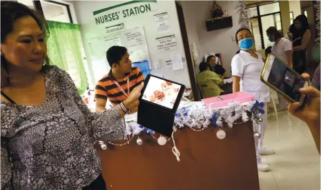  ?? (SUN.STAR FOTO/ALAN TANGCAWAN) ?? POSSIBLE CULPRITS. Businesswo­man Elena Chua shows a photo of the spaghetti and chicken that were served during an outreach program she organized for her neighbors in Barangay Sirao, Cebu City last Monday. Some 254 persons who ate the food were later...