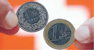  ??  ?? ‘‘Told you so’s’’: A Swiss 1 franc coin, left, and a
1 coin. The Swiss franc surged after their euro control was abandoned.