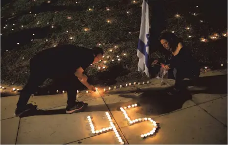  ?? FOTO: ODED BALILTY/DPA ?? Menschen zünden Kerzen zum Gedenken an die 45 ultraortho­doxen Juden an, die bei einer Massenpani­k bei einem religiösen Fest getötet wurden.