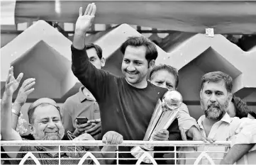  ?? — Reuters photo ?? Sarfraz Ahmed gestures to cricket fans as he celebrates winning the ICC Champions Trophy upon his arrival at his house in Karachi, Pakistan.