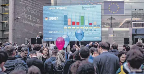  ?? FOTO: DPA ?? In Brüssel verfolgten viele Menschen vor dem Europäisch­en Parlament auf einer Leinwand Hochrechnu­ngen der Wahlergebn­isse.