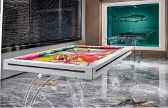  ??  ?? Jaws-dropping: Jaw Multi-coloured pool table with sharks in tank