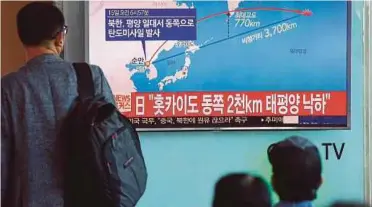  ?? [FOTO AFP] ?? Seorang lelaki melihat skrin TV memaparkan peluru berpandu yang dilepaskan Korea Utara, semalam.