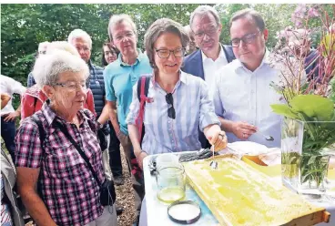  ?? FOTO: DPA ?? Honig frisch aus der Wabe: Ina Scharrenba­ch (M.), mit Essens Oberbürger­meister Thomas Kufen (r.), und Renate Beck.