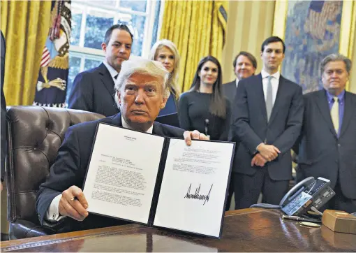  ??  ?? Órdenes ejecutivas. Donald Trump muestra su firma en una orden para restablece­r el proyecto de dos oleoductos que fueron parados por su antecesor, Barack Obama.