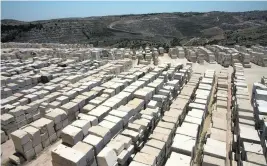  ?? Photos Heidi Levine for The National ?? Blocks of limestone on a hill overlookin­g the West Bank village of Beit Fajjer, between Bethlehem and Hebron, top. At Nassar Stone, right, a giant cutting tool carves out 2.9-tonne blocks to be turned into tiles for export while the blocks, left, show...