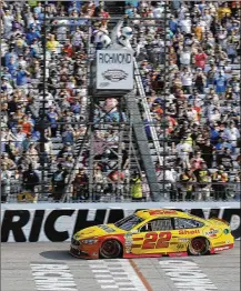  ?? STEVE HELBER / AP ?? Joey Logano takes the checkered flag to win the Toyota Owners 400 on Sunday at Richmond Internatio­nal Raceway. Logano finished just ahead of teammate Brad Keselowski.