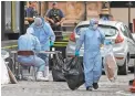  ?? FRANK AUGSTEIN/AP ?? Forensics officers carry away bags from the car that crashed into security barriers.