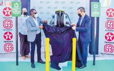  ?? ?? Evergo Jamaica CEO Wayne McKenzie (left) and his GB-Energy counterpar­t, Bela Szabo, unveil the Level 2 charging stations at Texaco Ironshore in Montego Bay, St James, in February.