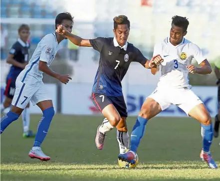  ?? — EPA ?? Hitting a roadblock: Park Mony Udom of Cambodia is tackled by Malaysia’s Shahrul Mohd Saad (right) during the AFF Suzuki Cup Group B match at the Thuwanna Stadium in Yangon on Sunday. Malaysia won 3-2.