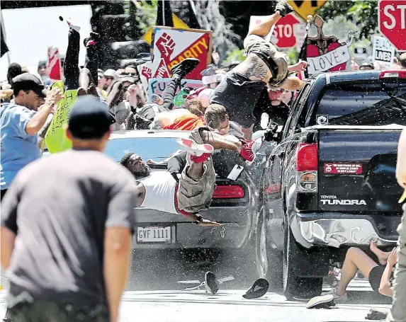  ?? Odpůrci pravicovýc­h extremistů a neonacistů létají vzduchem poté, co do nich v sobotu v Charlottes­villu najelo auto. Jedna žena zraněním podlehla. FOTO ČTK/ AP ?? Scéna jako z hororu.