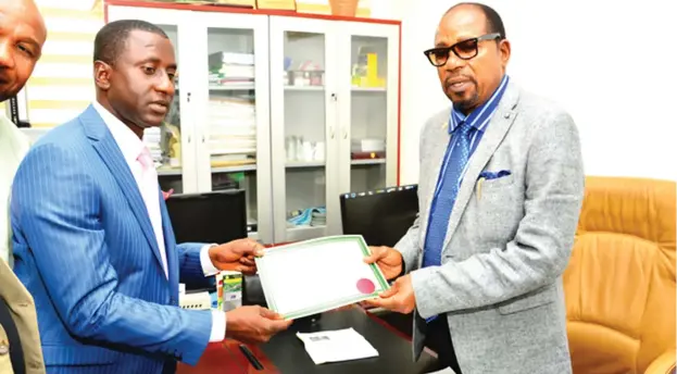  ?? PHOTO: INEC ?? Independen­t National Electoral Commission (INEC) National Commission­er in charge of South East, Ambassador Lawrence Nwuruku (right) hands over the Abia State gubernator­ial Certificat­e to Dr Sampson Uchechukwu Ogah yesterday as the rightful winner of...