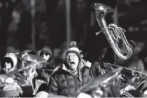  ??  ?? Musician Hugh Pote holds up his baritone as he shouts his age – 89 years young – when introduced as the oldest musician performing in the Tuba Christmas concert at Skyline Park.