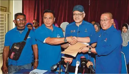  ?? BERNAMA PIC ?? Former Larut PPBM secretary Shafie Mohd Khairy (second from left) presenting Umno membership forms to Larut Umno division chief Datuk Faizul Arby Mohd Shohor in Larut yesterday. With them is Larut member of parliament Datuk Seri Hamzah Zainudin (second...