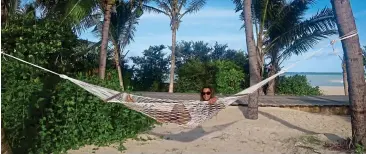  ??  ?? BLUE HEAVEN: Dining out, Maldivesst­yle at Soneva Jani, above, and, left, Christa relaxing in a hammock at the resort