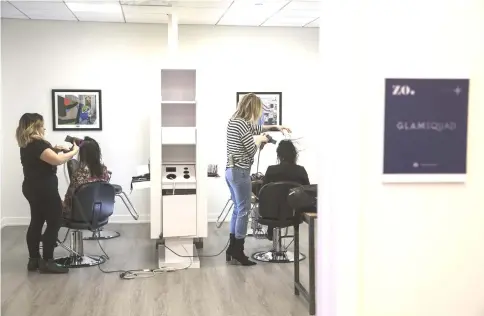  ??  ?? Stylists blow-dry hair at a salon offered by the Tishman Speyer Properties LP Zo programme and app at the centre.