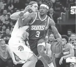  ?? PATRICK BREEN/THE REPUBLIC ?? Suns guard Bradley Beal dribbles against Raptors forward Kelly Olynyk during Thursday’s game at the Footprint Center.