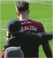  ??  ?? Danger zone: the pitch invader catches Jack Grealish completely off guard as he approaches from behind, swings his right arm around the Aston Villa