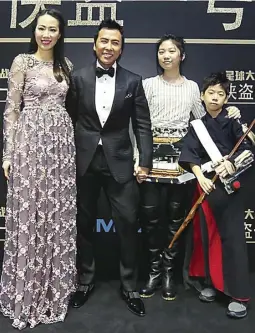  ?? HOLLYWOOD REPORTER ?? AJAK KESAYANGAN: Donnie Yen bersama istrinya, Cissy, dan putrinya, Jasmine, serta anak laki-lakinya, James, yang mengenakan kostum Chirrut Imwe di Beijing, Tiongkok, pada Kamis lalu (22/12). Wars