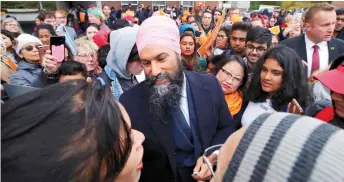  ?? — AFP photo ?? Jagmeet (centre) and Canada’s NDP candidate for Beaches-East York Mae J. Nam meet with voters during an election campaign visit stop at Crescent Town Elementary School in Toronto, Ontario.