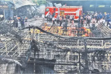  ??  ?? Indonesian forensic policemen work after a fire disaster in Tangerang Kota, Banten province. — AFP photo