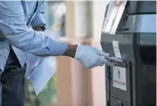  ?? EVE EDELHEIT/THE NEW YORK TIMES ?? A gloved voter drops off a mail-in primary ballot at the Pinellas County Election Services office in St. Petersburg.